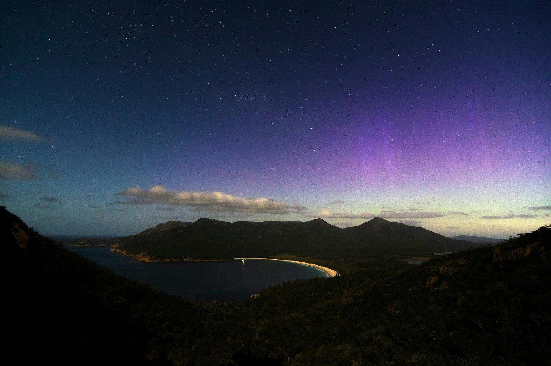 The Aurora appears over Wineglass Bay at Freycinet National Park, Tasmania