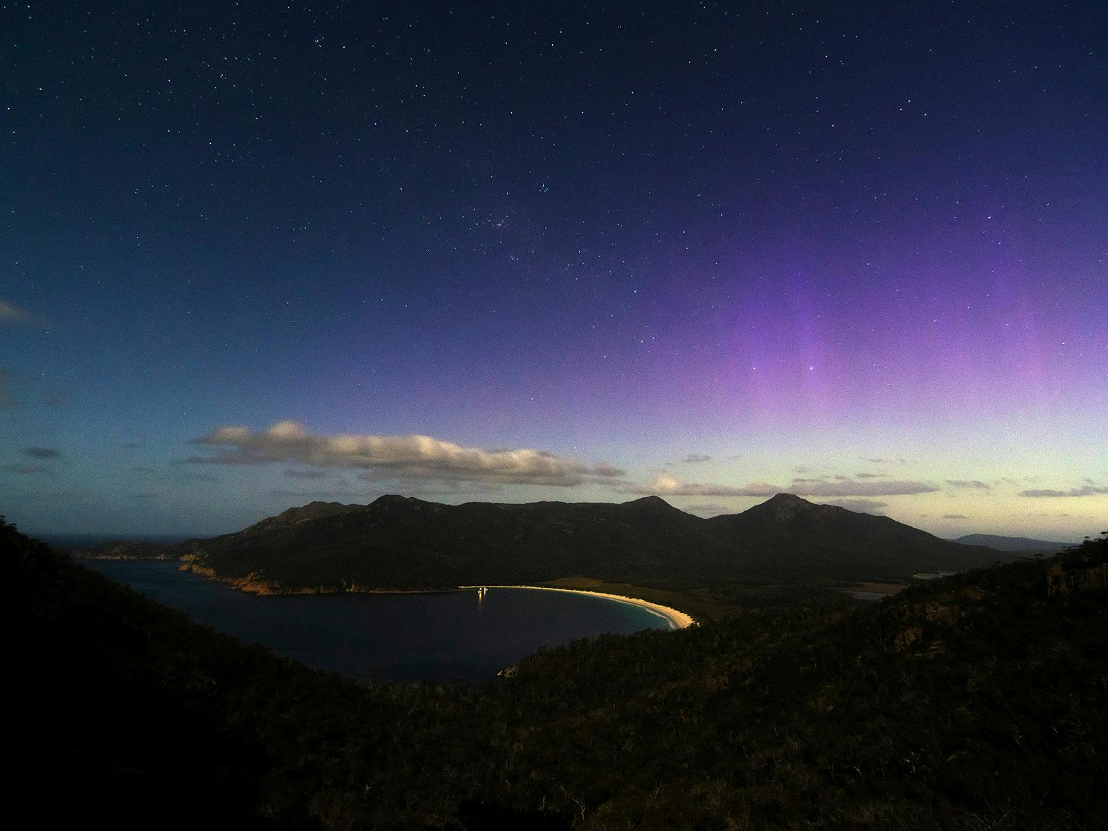 The Aurora appears over Wineglass Bay at Freycinet National Park, Tasmania