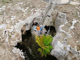 Small group of people peering into a cave opening