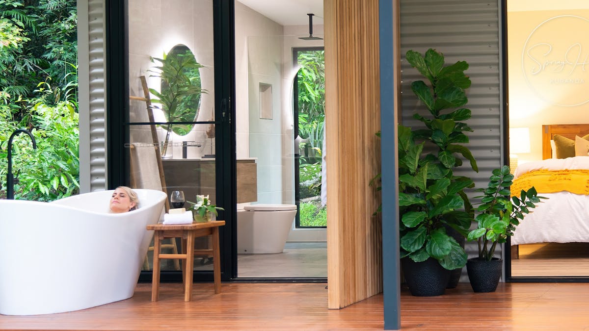 Guest relaxing in outdoor bath on the deck at Spring Haven Kuranda