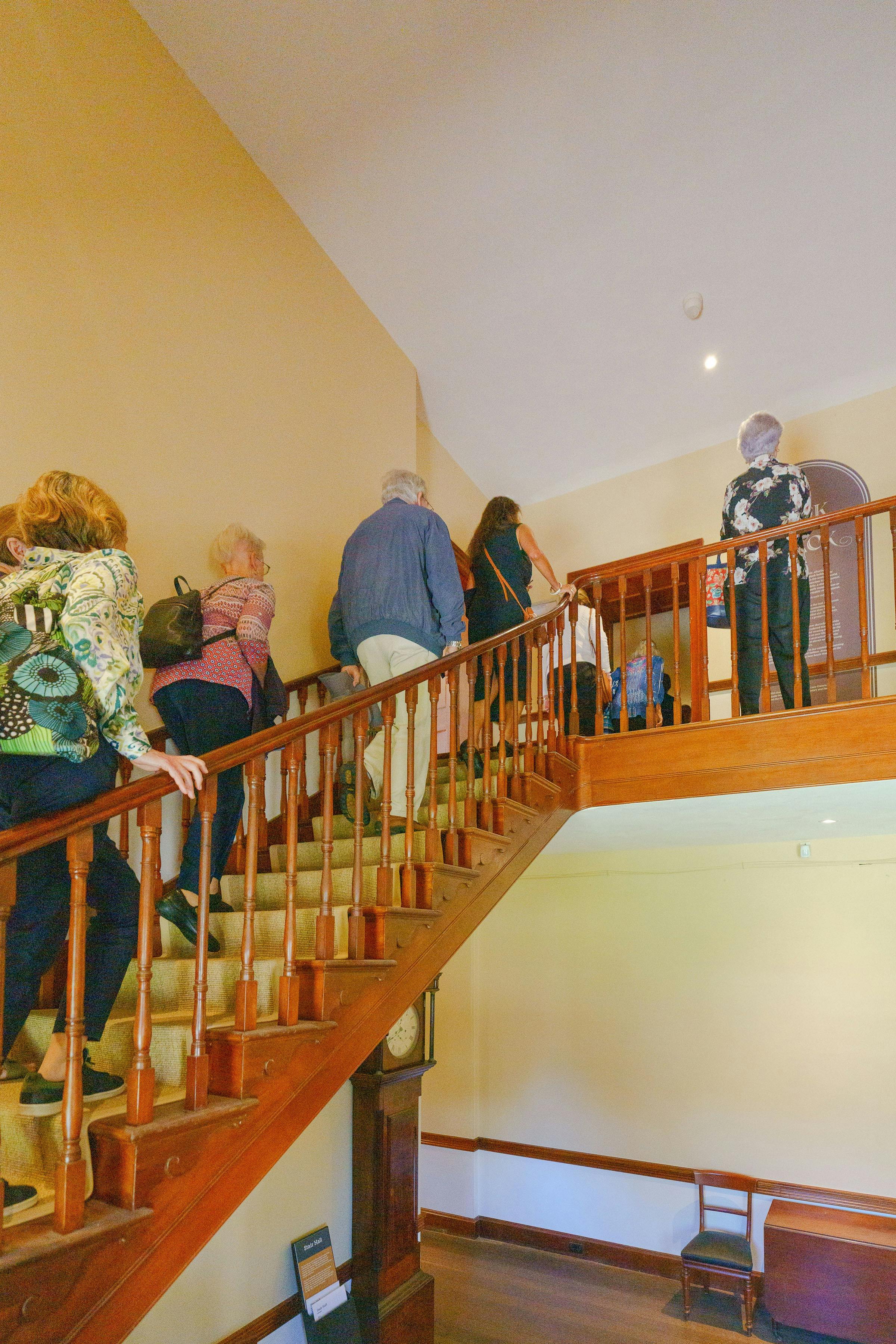 People walking up stairs inside historic home