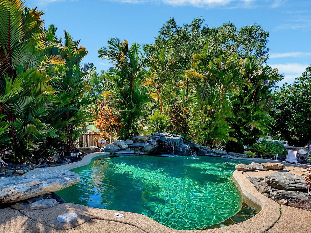 Resort pool surrounded by lush tropical garden