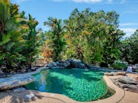 Resort pool surrounded by lush tropical garden