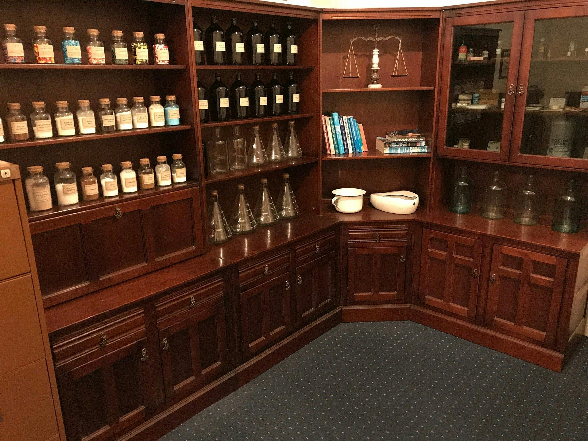 Photo of replica pharmacy shelving with pills, powders and potions.