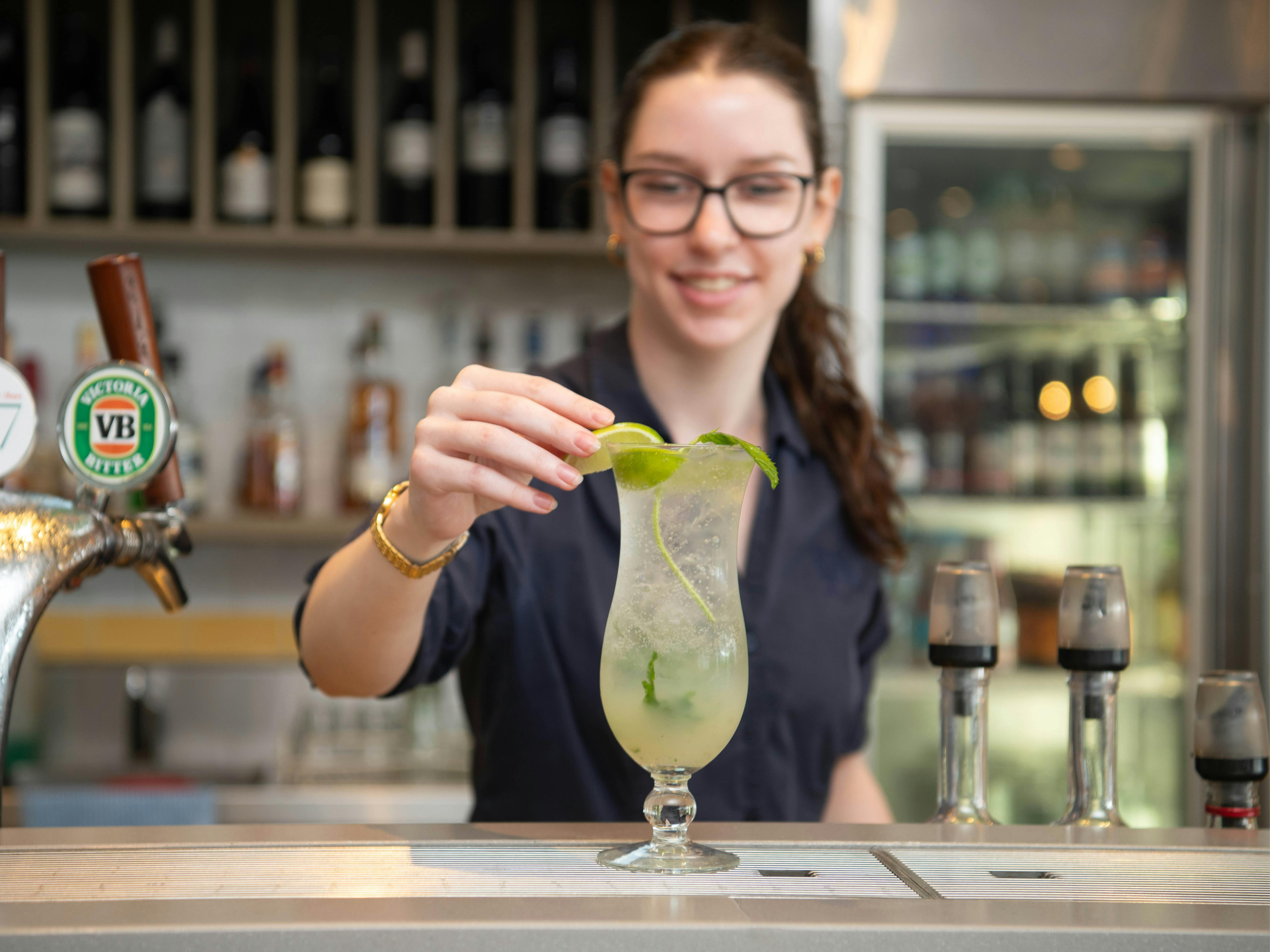 Frau mixt Cocktails in der Tap Inn Bar