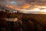 Aerial view. Taken at sunset with the lookout and a man and a women standing against the railing.