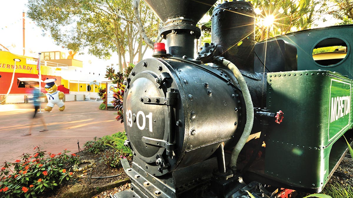 Close up of Moreton the Ginger Train, with the Overboard boat ride in the background