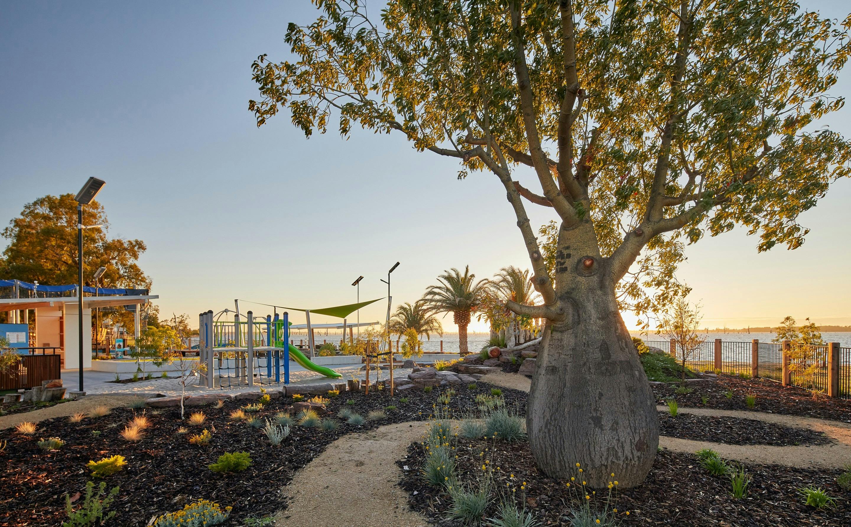 A rugged path winds through garden at Purtle Park, with play facilities in the background.