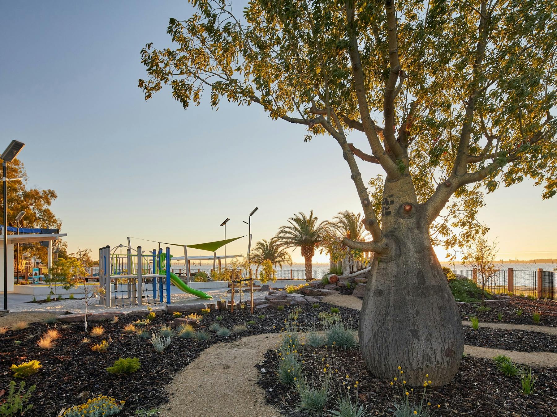 A rugged path winds through garden at Purtle Park, with play facilities in the background.