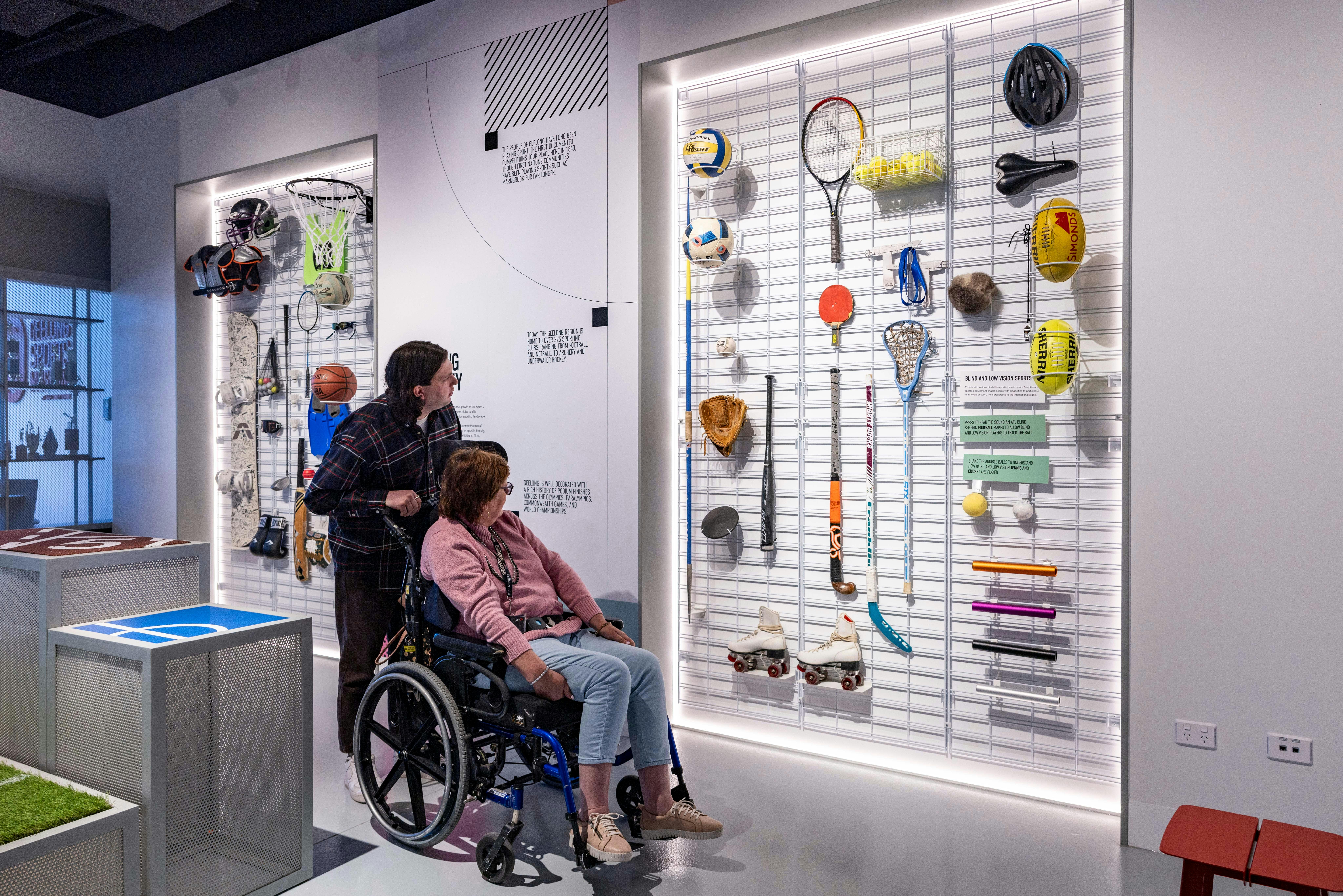 Lady with accessible needs and carer looking at artifacts