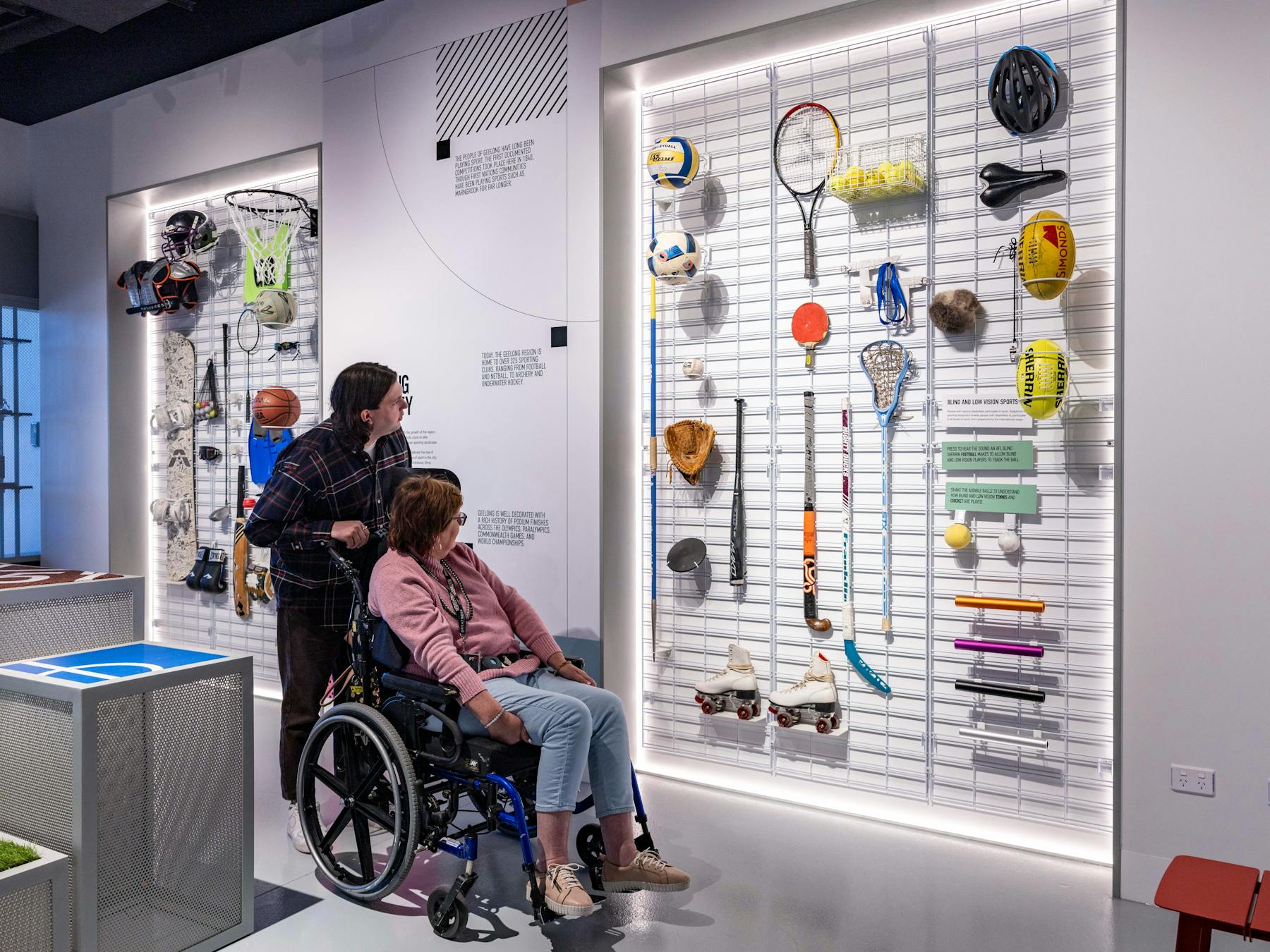 Lady with accessible needs and carer looking at artifacts