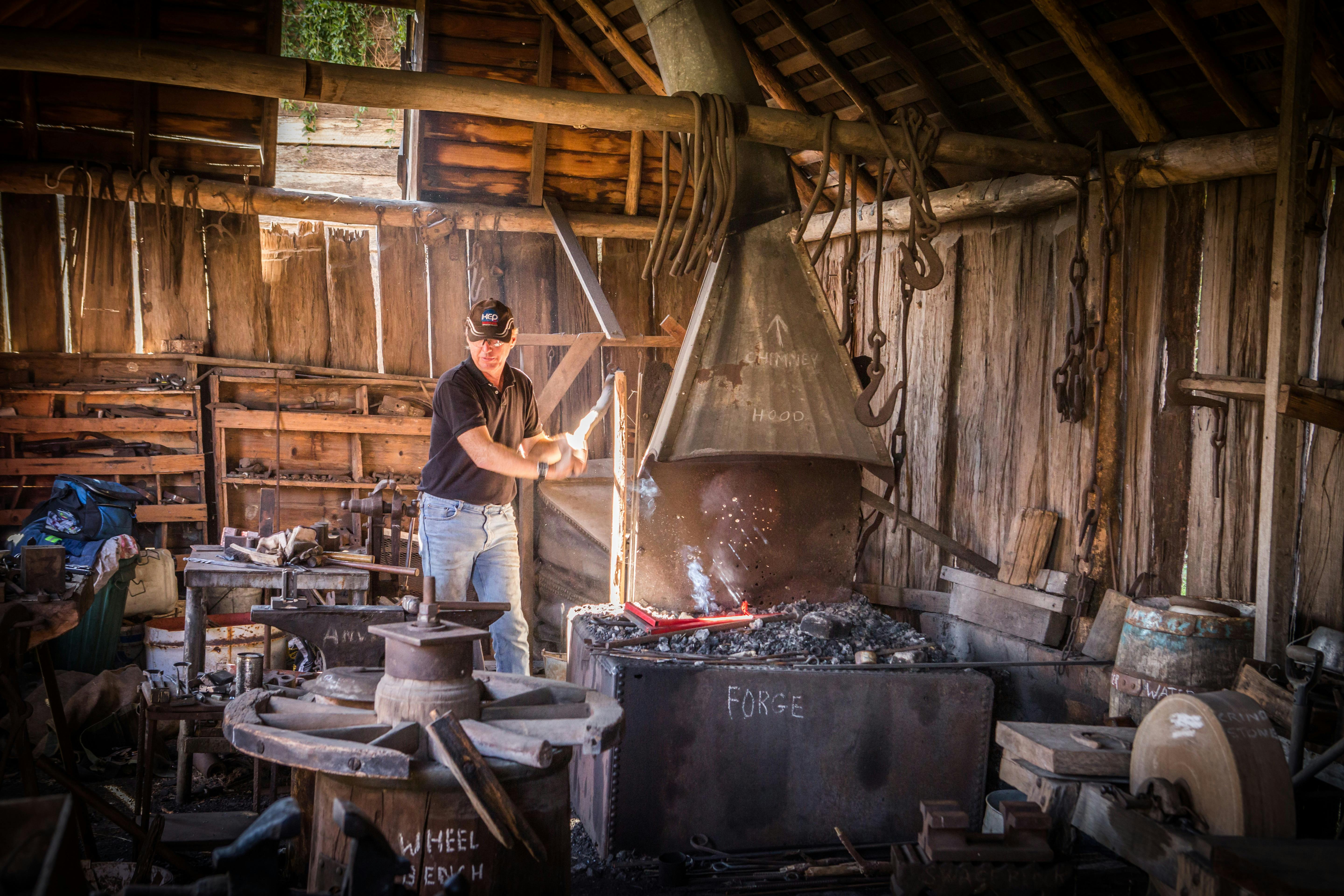 Blacksmith live in action heating metal in a forge.
