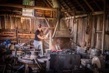 Blacksmith live in action heating metal in a forge.