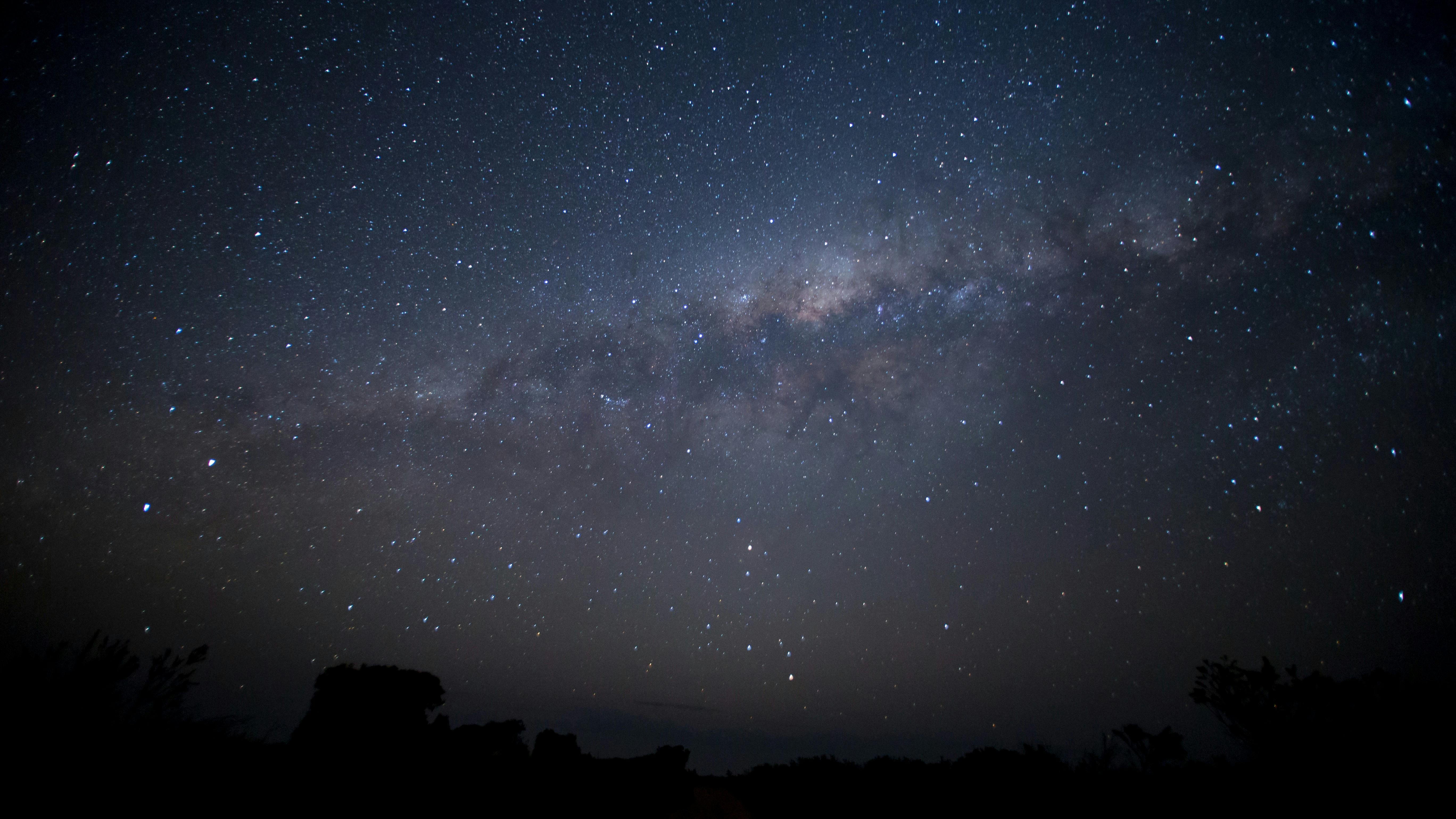 Astrophotograph of purple milkyway in deep blue sky filled with stars