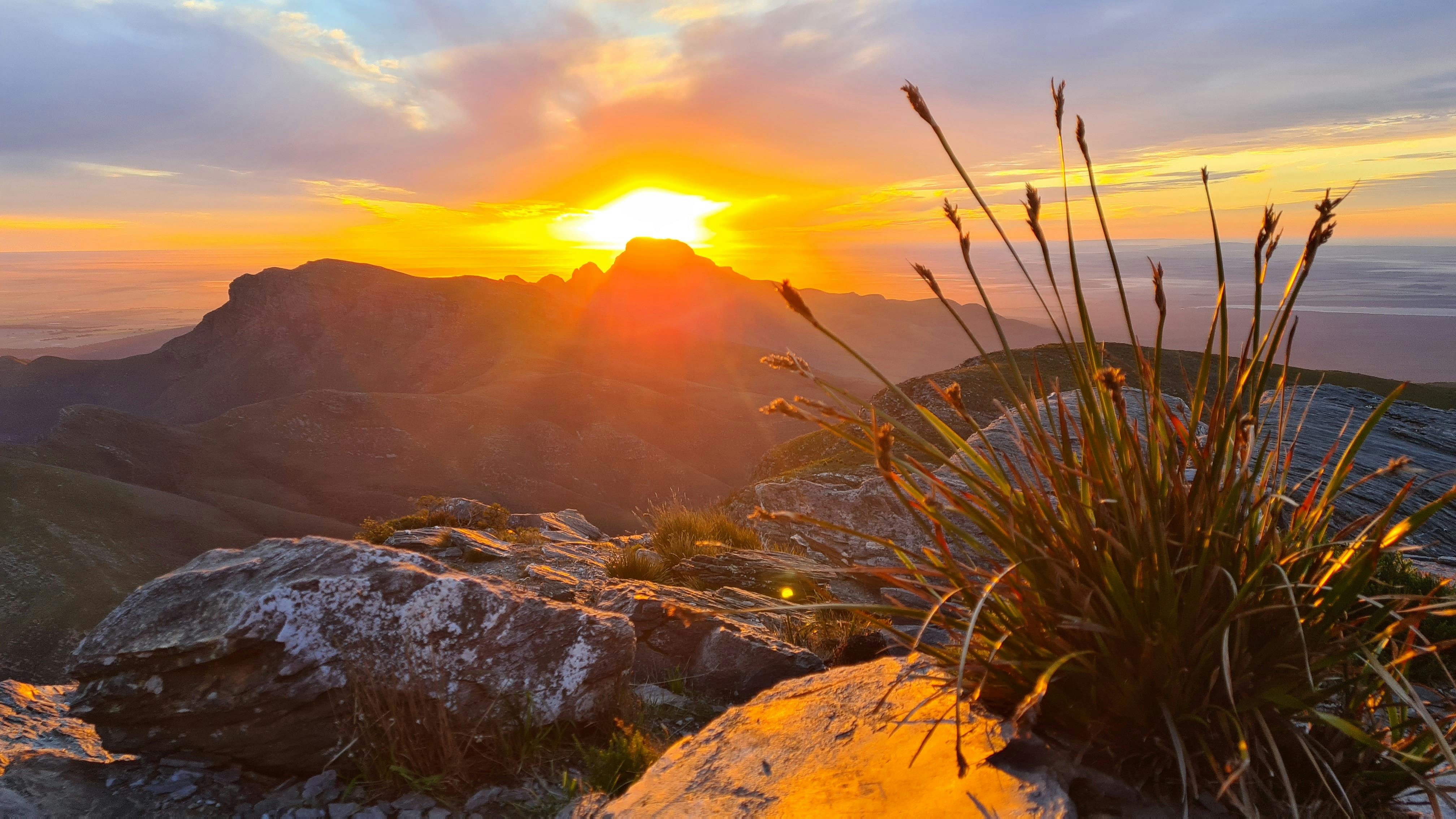 Sun rising behind mountains with orange glow filling the sky