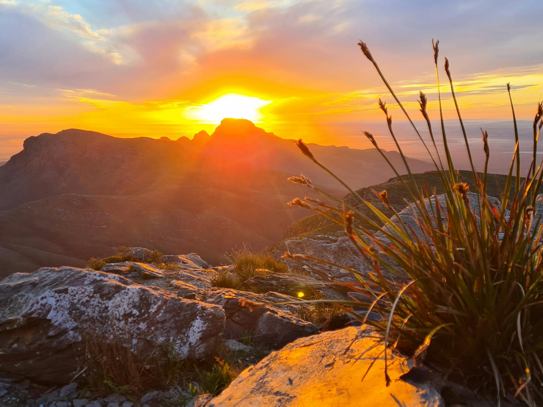 Sun rising behind mountains with orange glow filling the sky