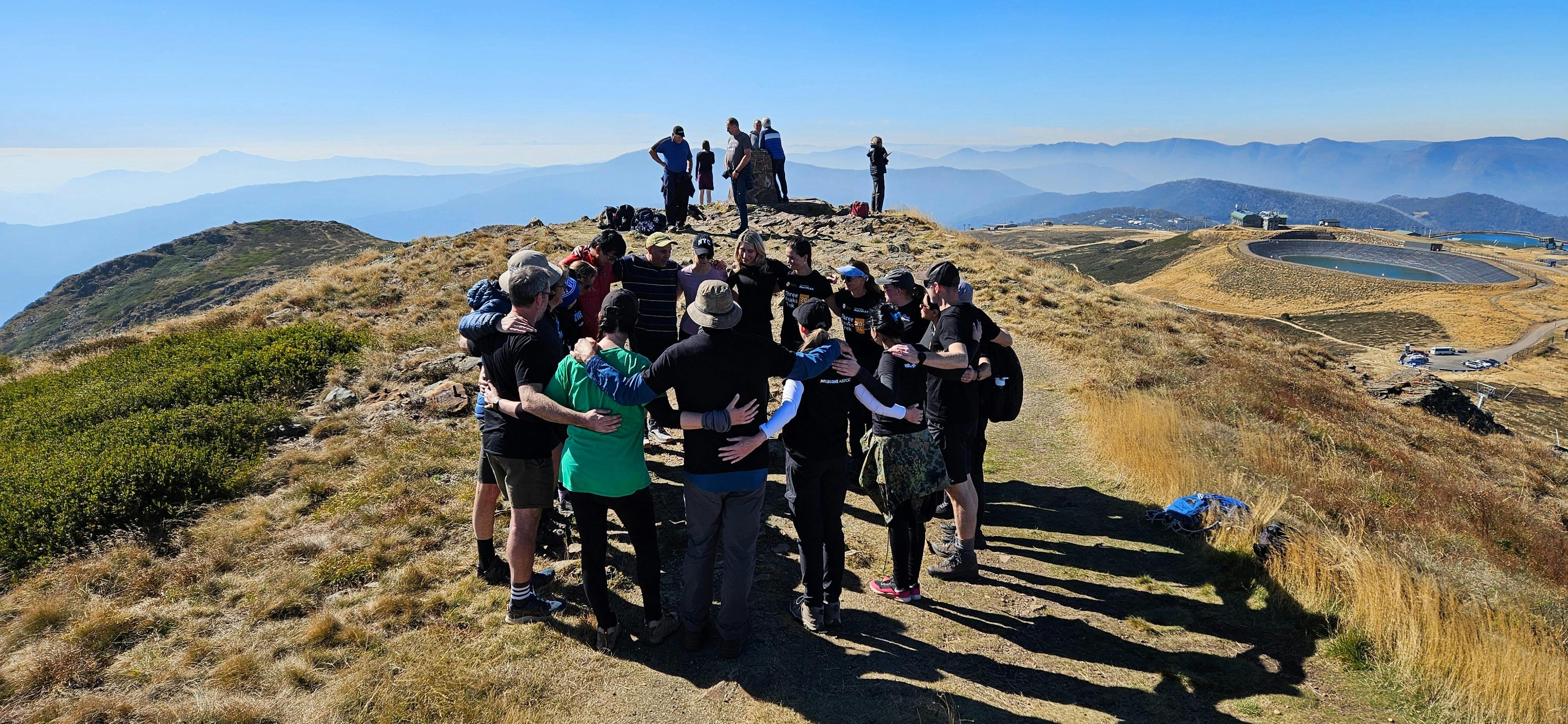 Hikers celebrating the last summit on a three day hike on top of Mt Buller.