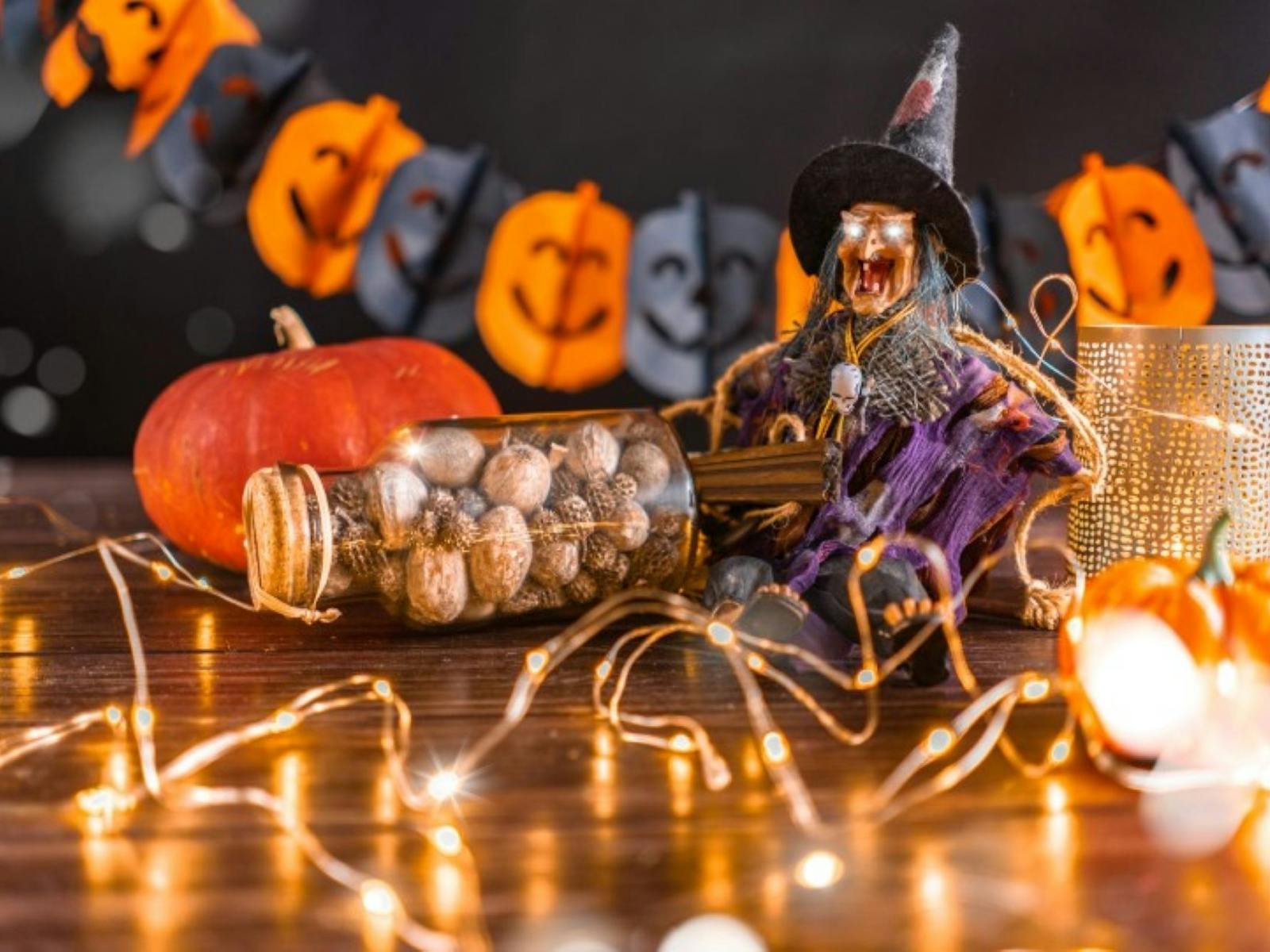 Halloween decorations laid out on a table with fairy lights