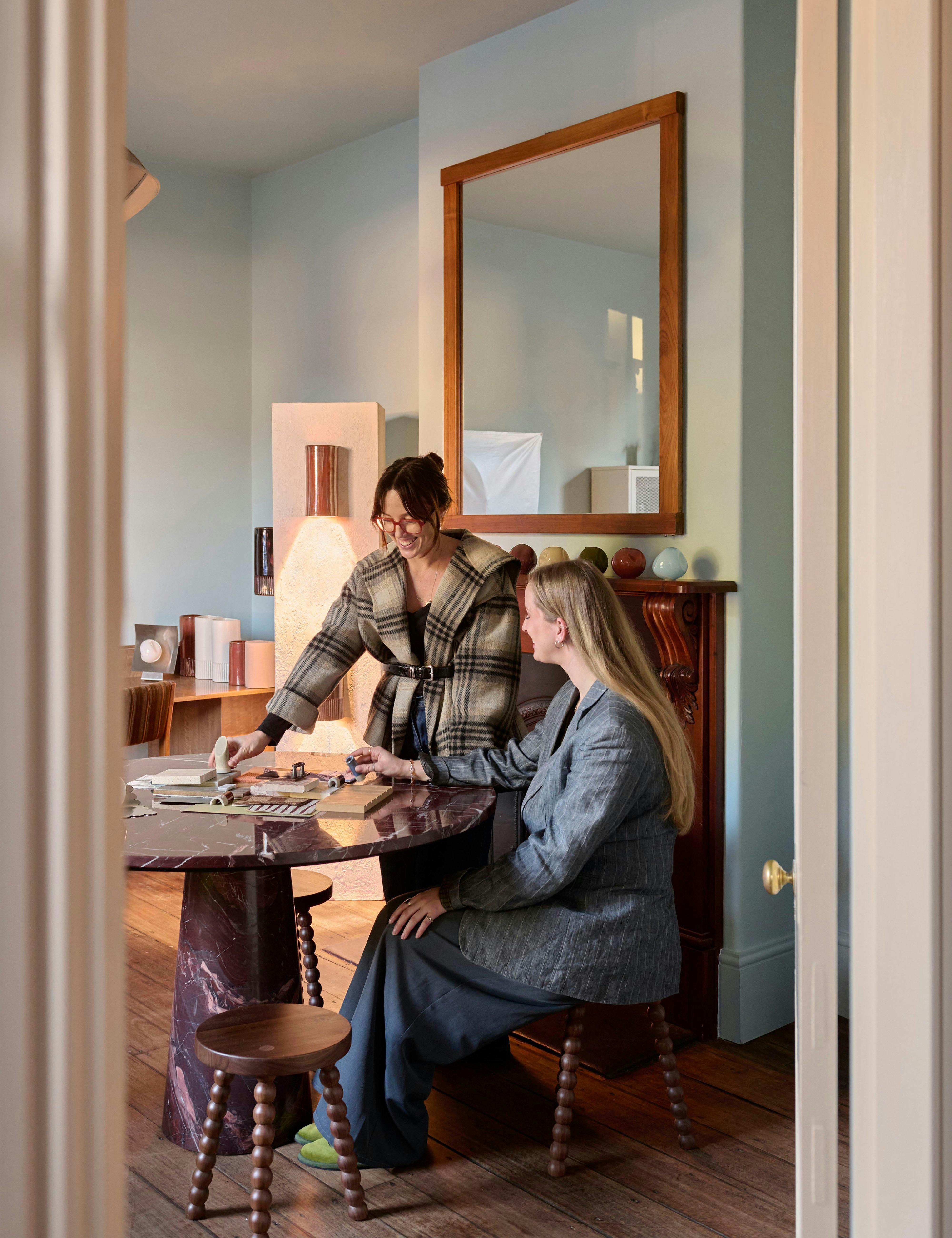 Rose Kiselev and a colleague reviewing material samples at a table in the We Ponder studio.