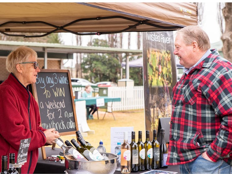 Woman selling wine to a man from market stall