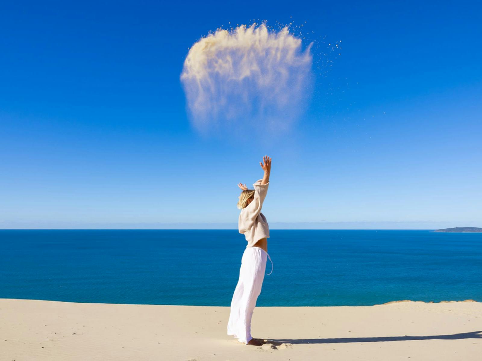 A lady at Carlo Sandblow throwing sand in the area