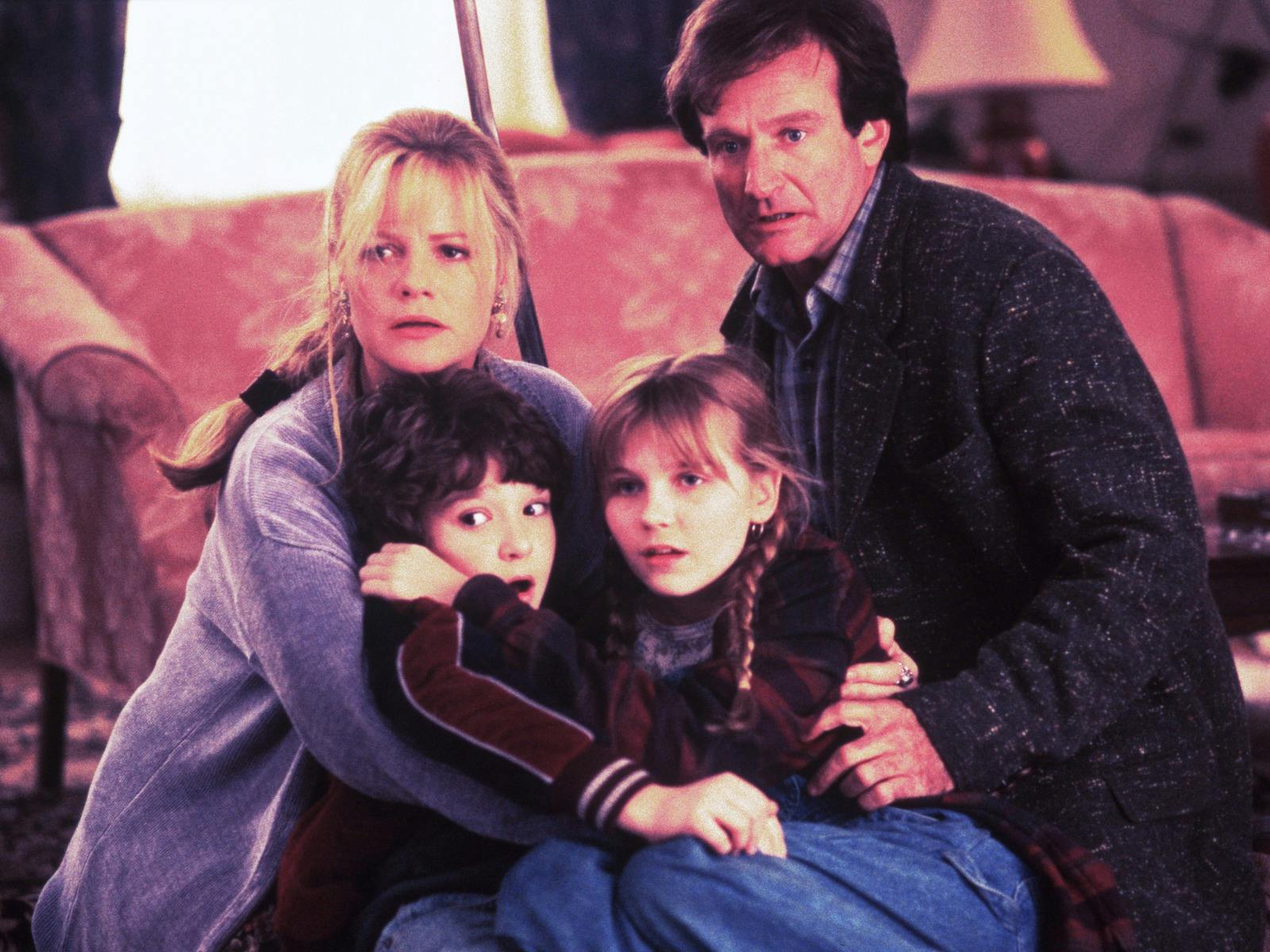 A family of four looking past the camera, huddling together scared