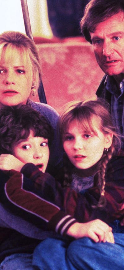 A family of four looking past the camera, huddling together scared