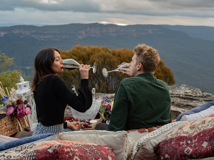 Two people drinking wine over looking a valley