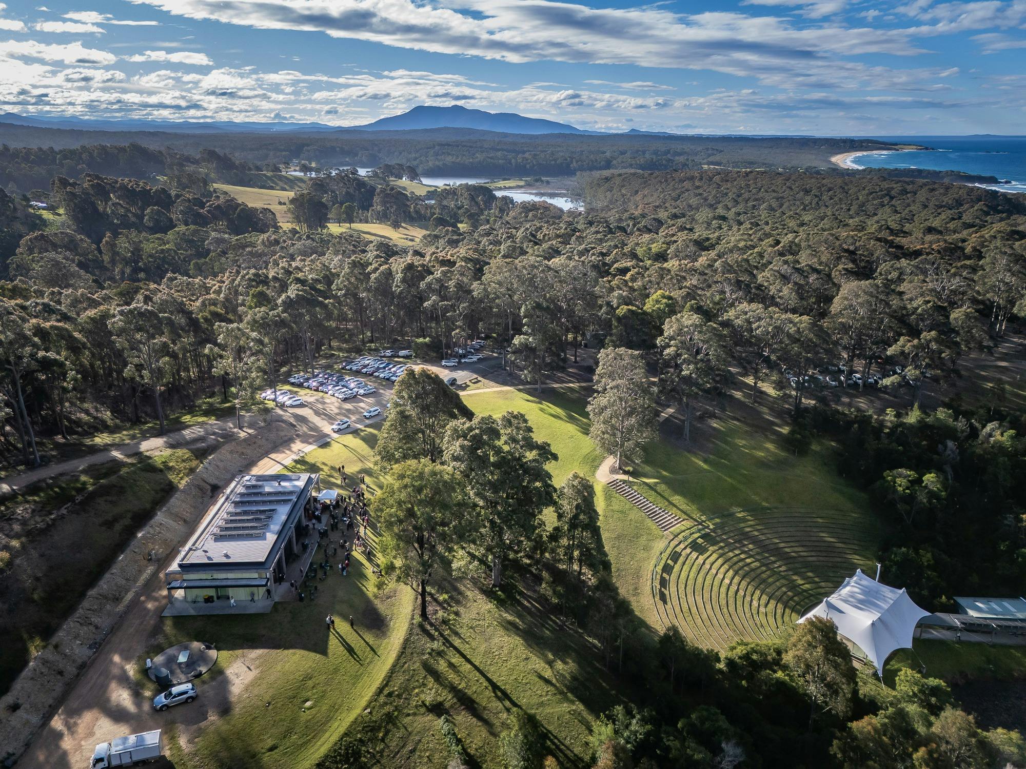 Drone image of the Four Winds site featuring bushland, mountains and water surrounding