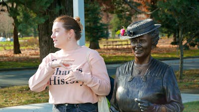 Tour guide Eliza standing next to statue of Dorothy Tangney