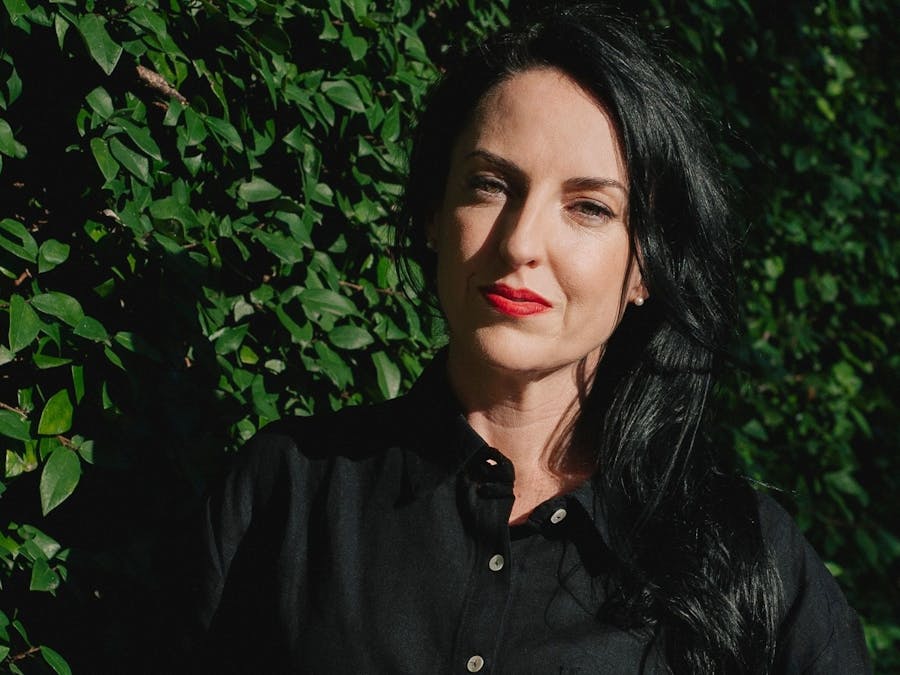 Headshot of woman with long black hair wearing a black shirt