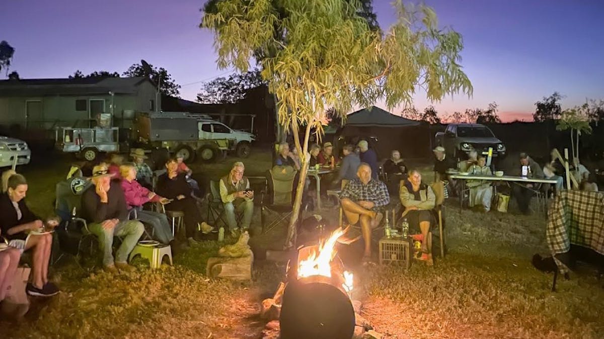 people sitting around a fire at Julia Creek Caravan Park Bush Dinner