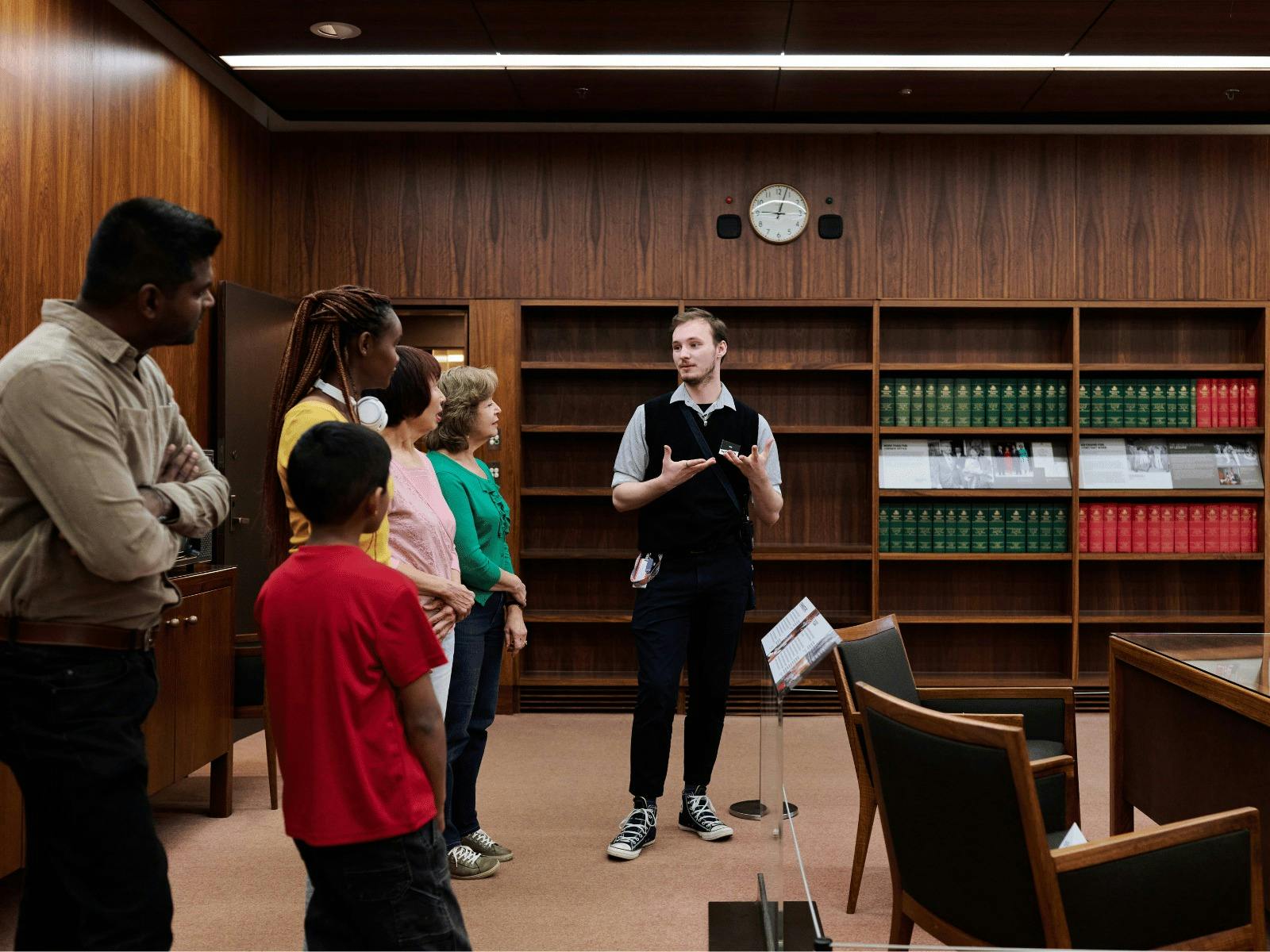 A MoAD Museum Experience Officer speaks to a group of people gathered in the Prime Minister's office