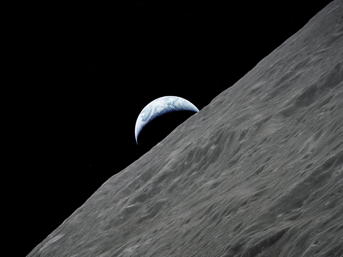 三日月形の地球が月の地平線から昇る。写真:NASA