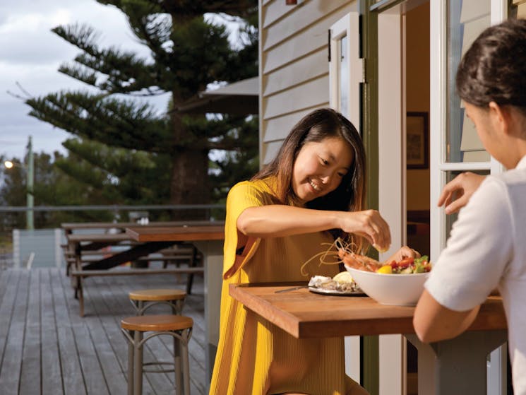 Couple enjoying fresh seafood available on the menu at Tathra Hotel, Tathra