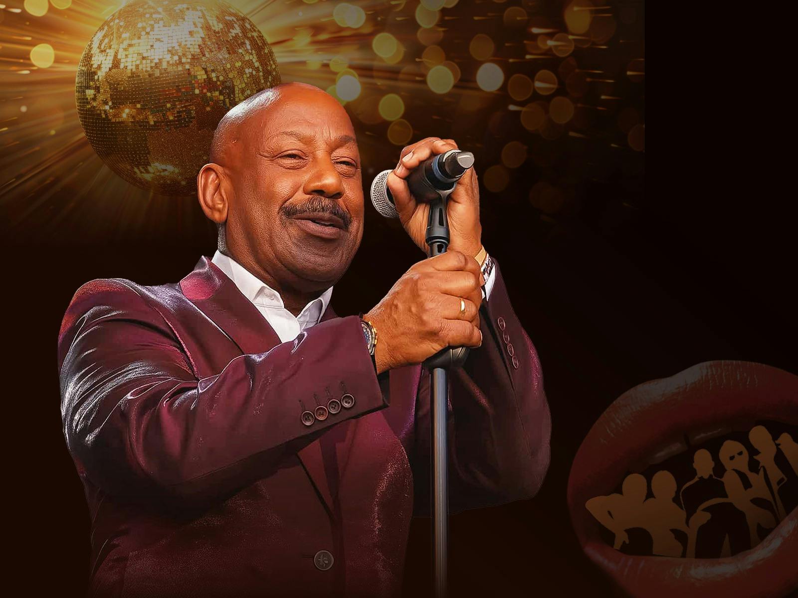 Man singing into a microphone wearing a maroon tuxedo with a gold disco ball in background