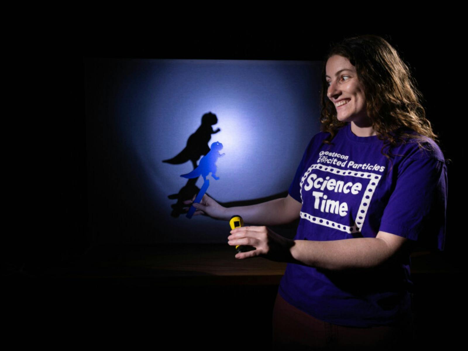 A woman making a dinosaur shadow in Science Time