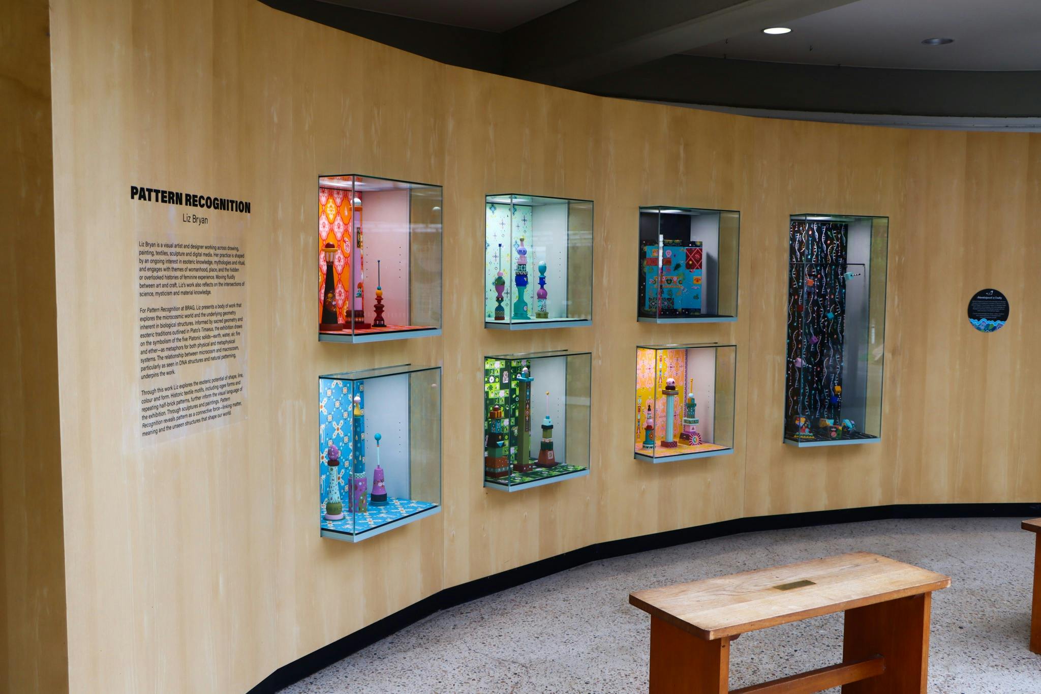 7 display cabinets filled with colourful, wooden block towers and patterns