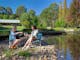 Friends enjoying wine by the water at Hume House Merrijig
