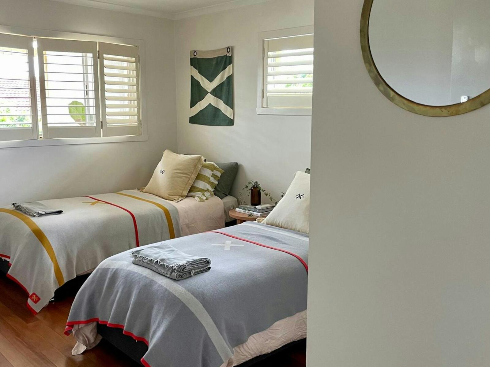 Bedroom with two single beds, two windows and mirror on wall
