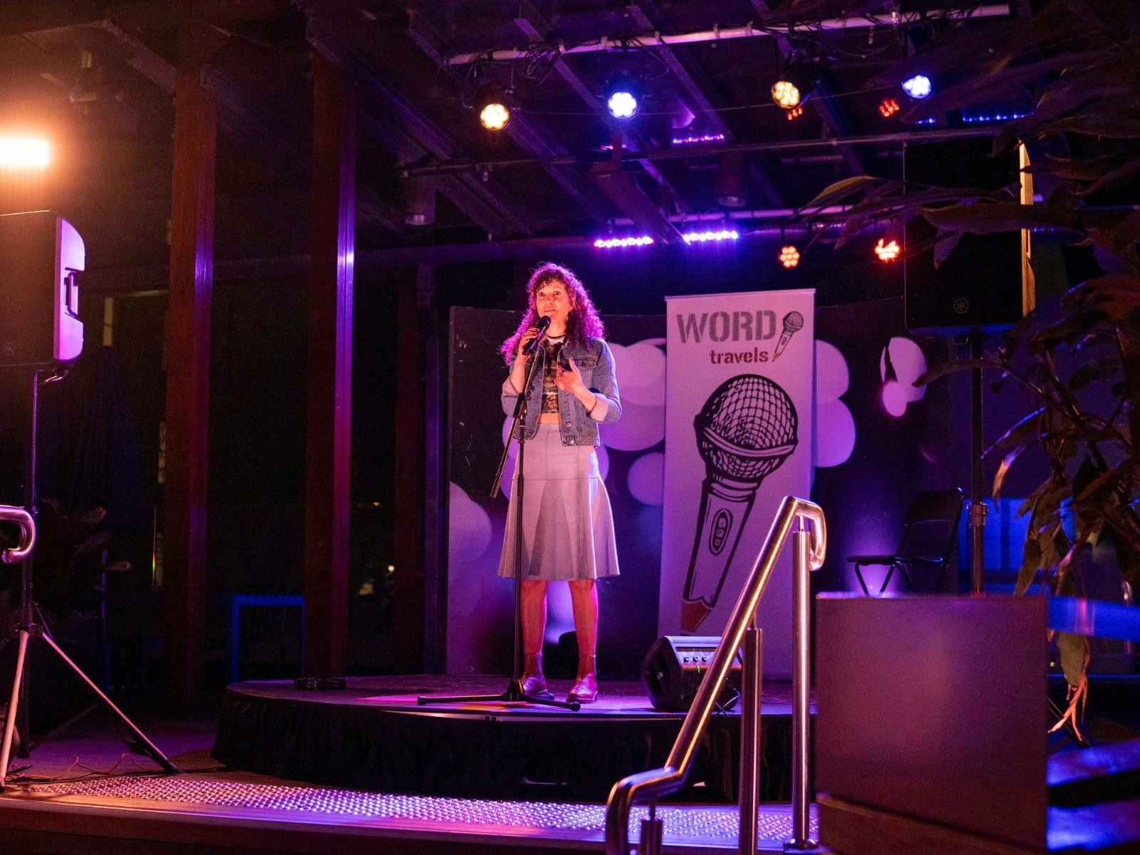 Woman on stage reciting poetry