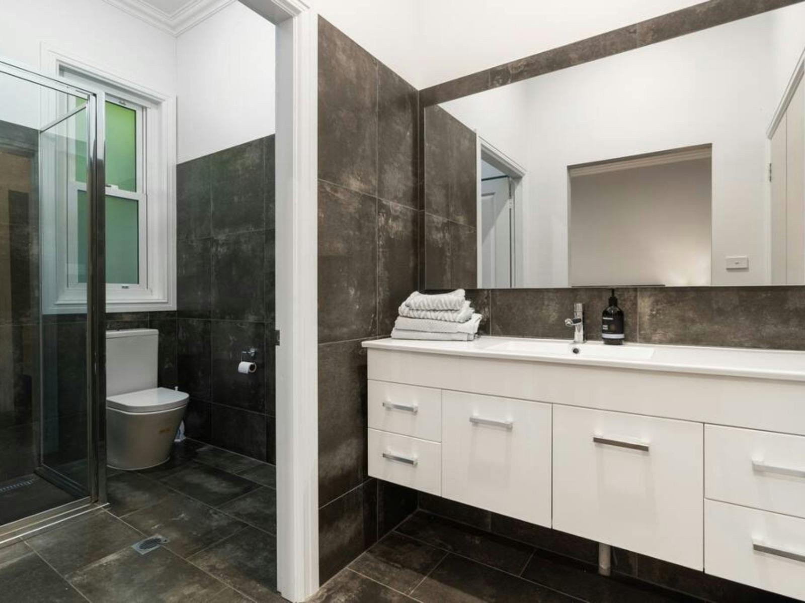 Large bathroom with vanity, shower and toilet.