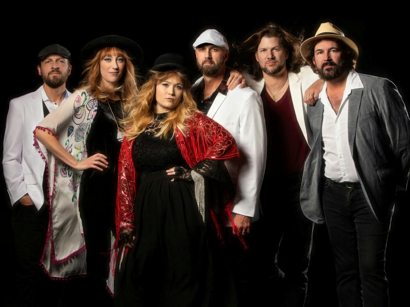 Image of four men and two women. a band in front of a black screen a