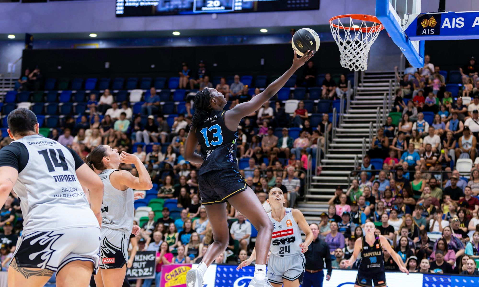 UC Capitals player driving to the basket for a layup during a WNBL game.