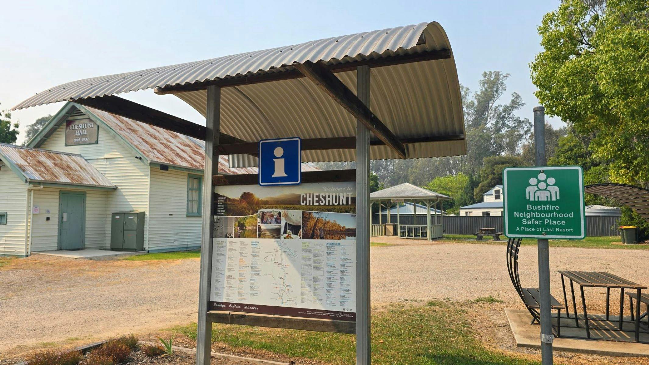 Signs under a small rotunda offering Visitor Information, and a Place of Last Resort Bushfire sign