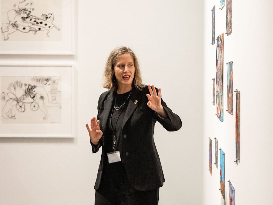 A tour guide discussing one of the artworks on display