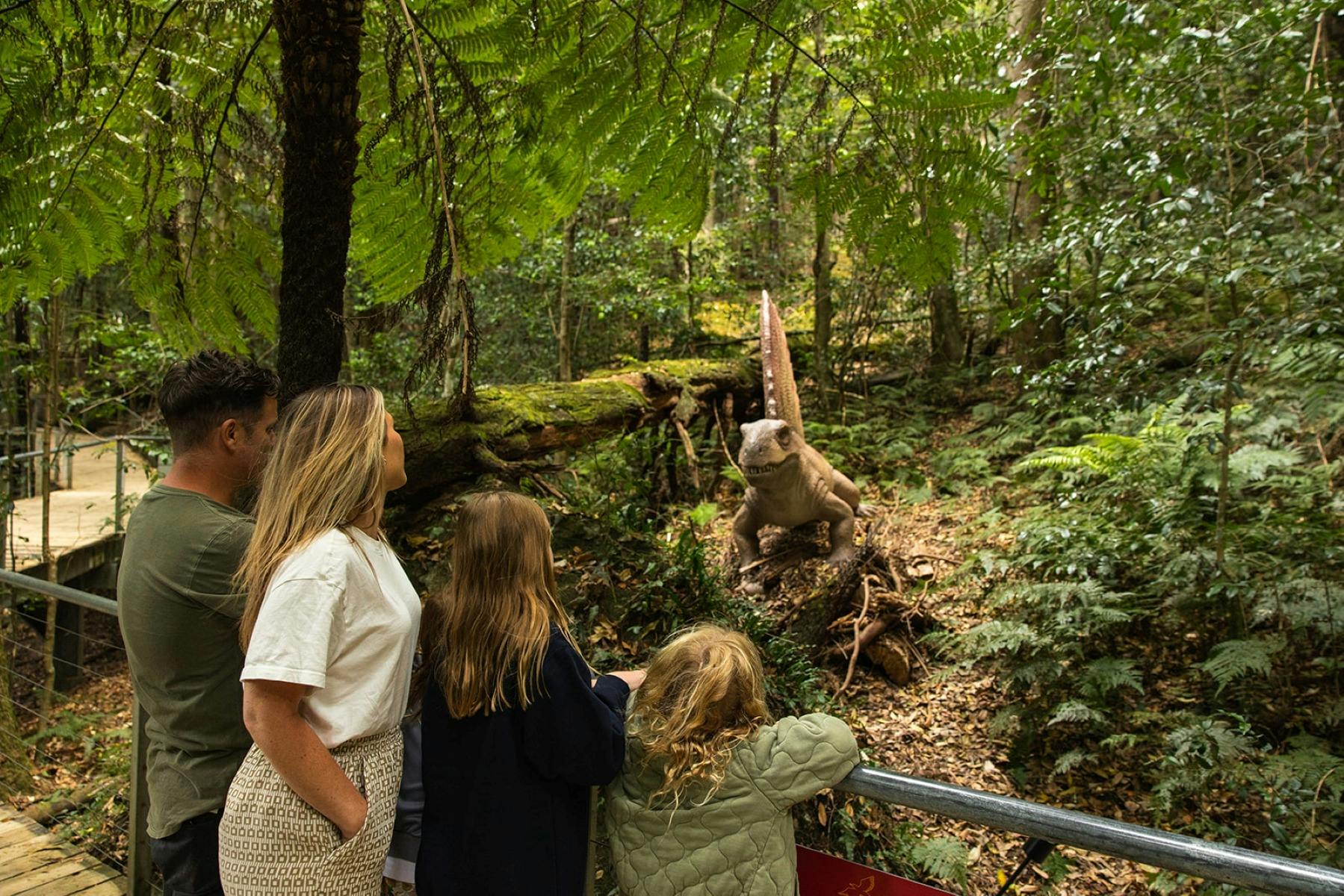 A family looking  a dinosuar in the rainforest