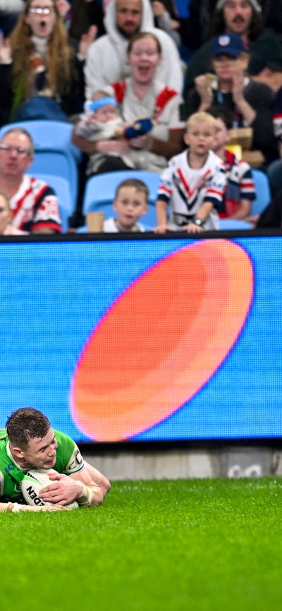 Canberra Raiders player Hudson Young scoring a try as Sebastian Kris celebrates.