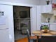 Kitchen table, fridge, kitchen cupboards, oven. Lounge chair tv