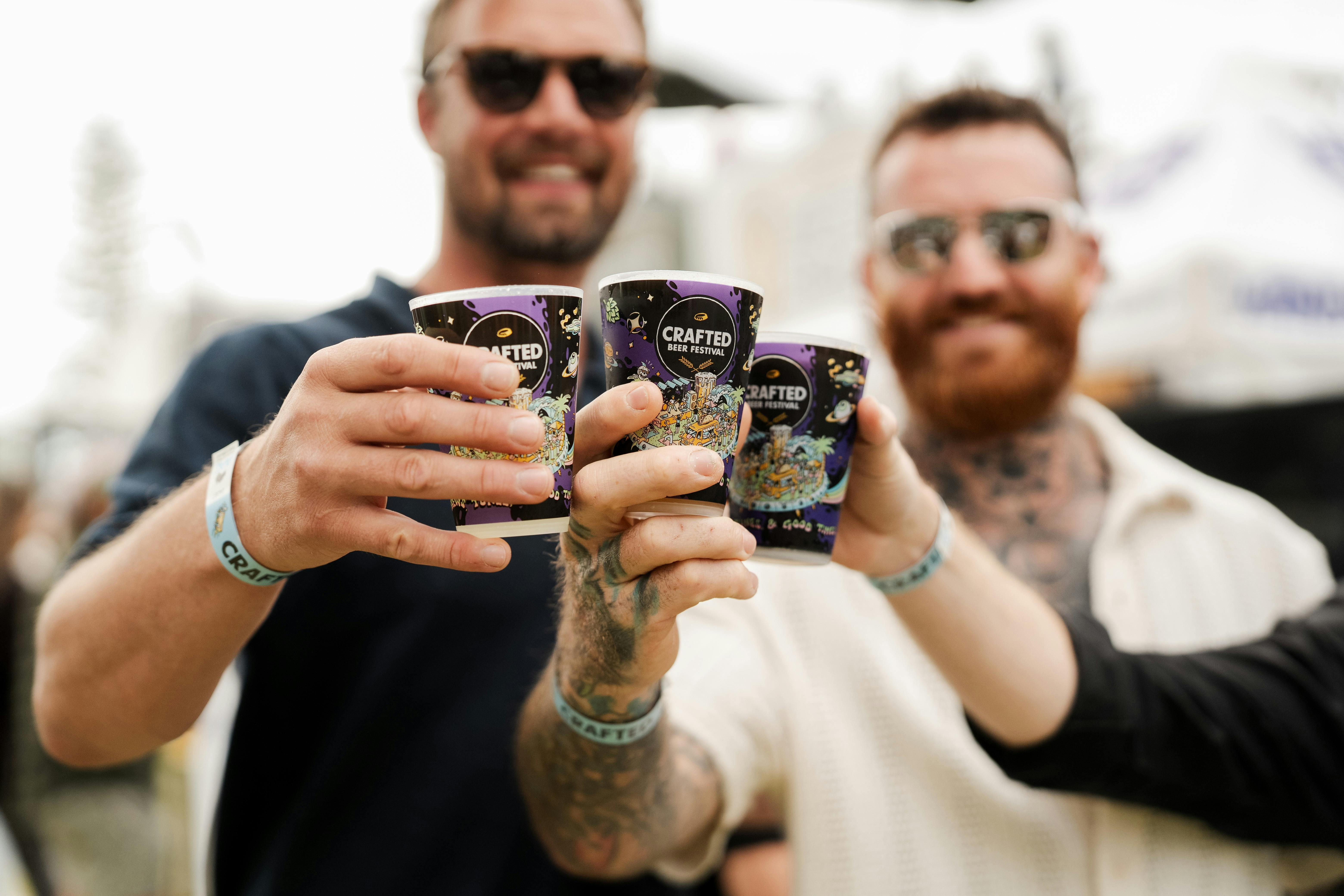 Two men cheersing their beers to the camera